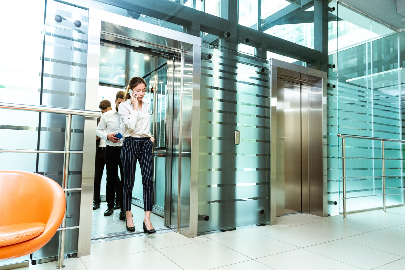 Business team group going on elevator. Business people in a large glass elevator in a modern office. Corporate businessteam and manager in a meeting