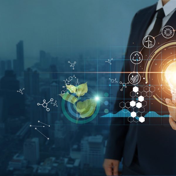 businessman holding light bulb against nature on city background  with icons energy sources for renewable, sustainable development,  Ecology and renewable energy concept.